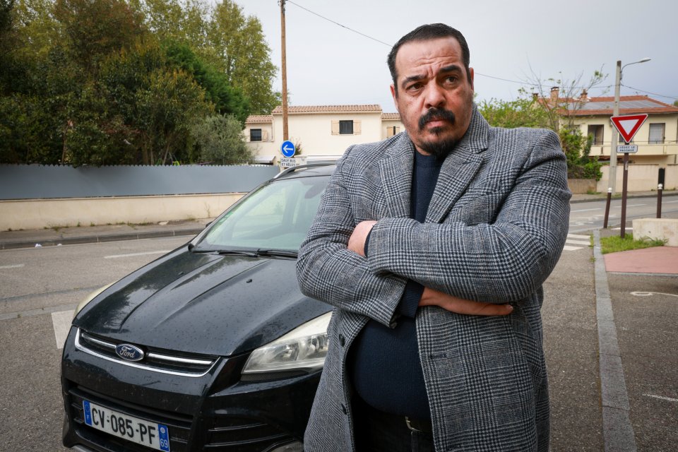 Private hire driver Nasim Mimun standing by his car.