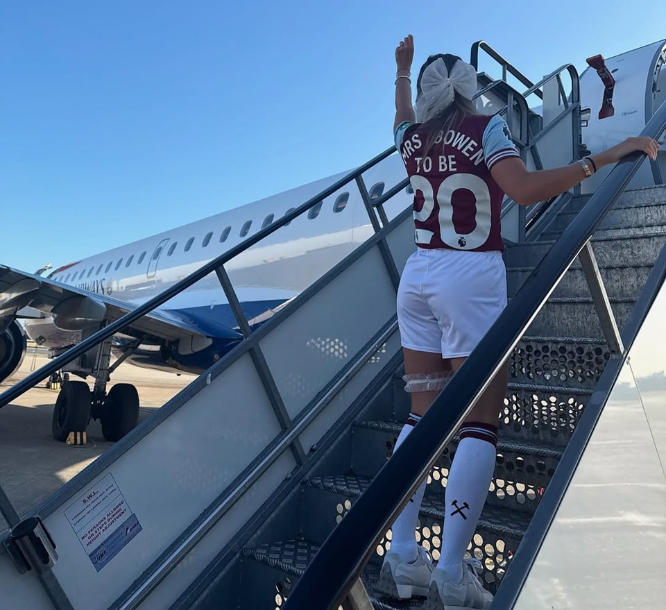 Woman in a West Ham United jersey boarding a plane.