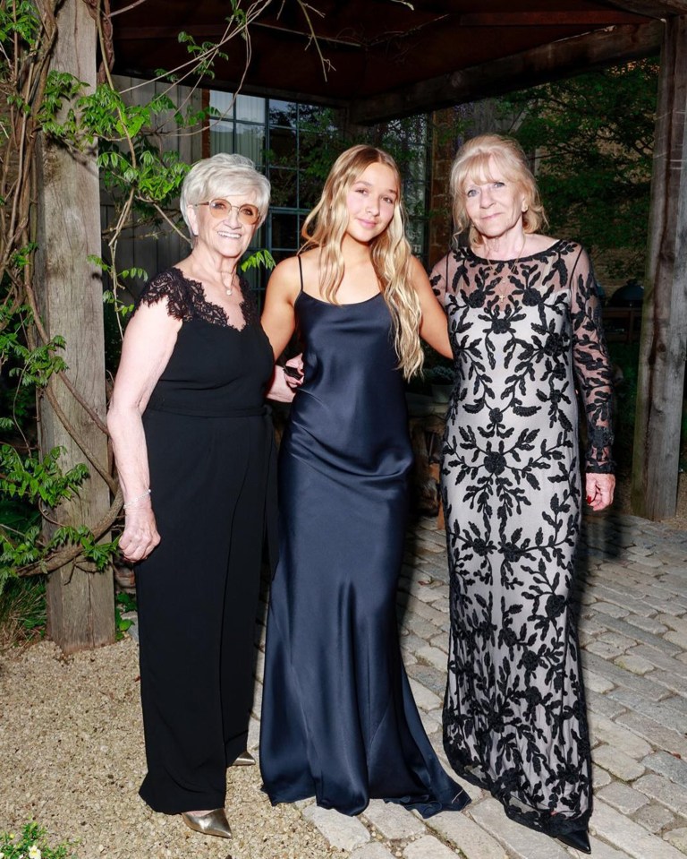 Three women in formal dresses at an outdoor event.