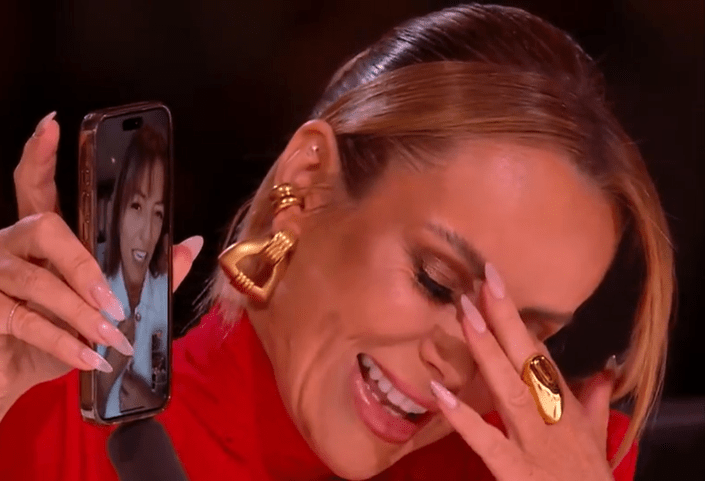 A woman on Britain's Got Talent crying while looking at a video call on her phone.