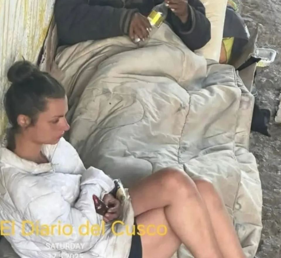 Photo of a young woman sitting on the ground, appearing homeless.