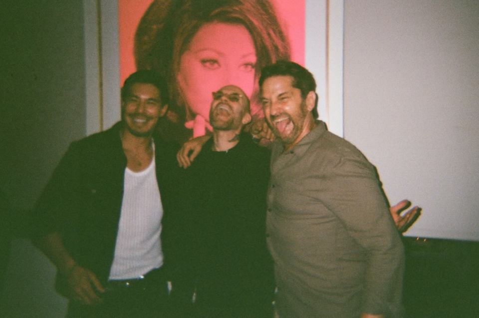 Three men posing together at a party.