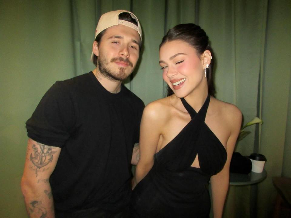 Brooklyn Peltz Beckham and a man posing together.