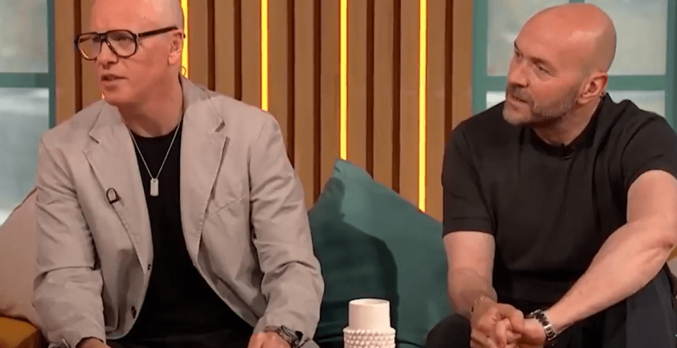 Two men sitting on a couch, in conversation.