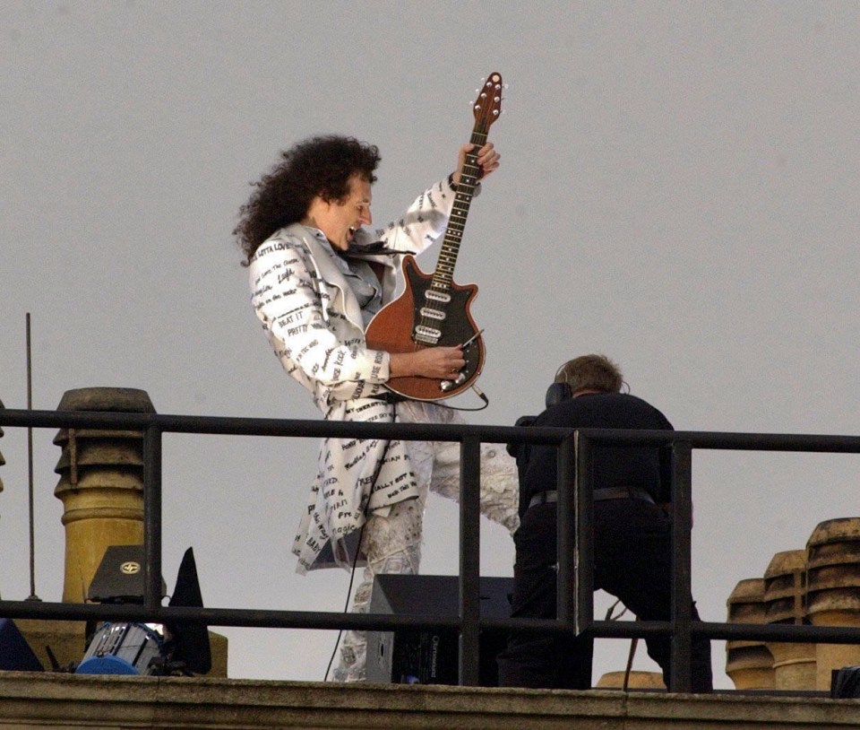 Brian May performing on the roof of Buckingham Palace.