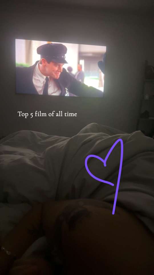 Couple watching a movie in bed.