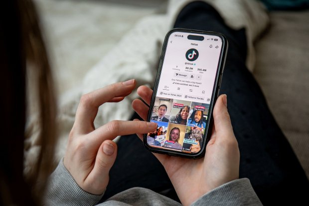 Person using a smartphone to view TikTok videos.