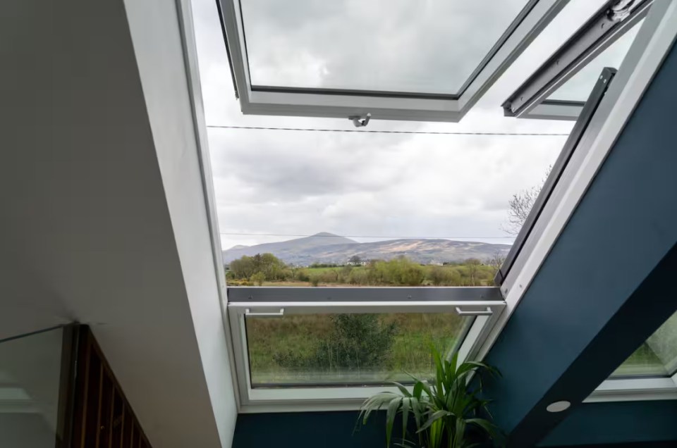 Open skylights showing a view of a rural landscape with hills.