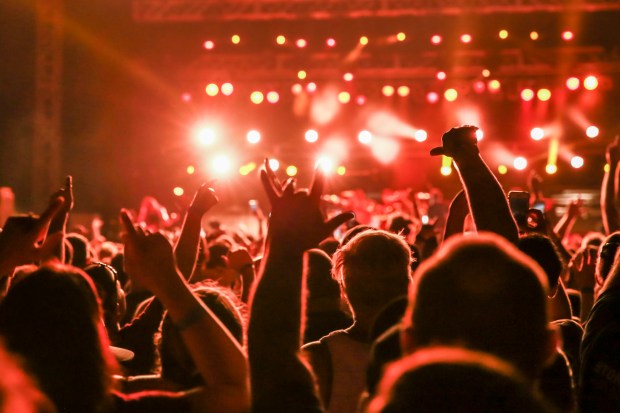 Concert crowd with arms raised.