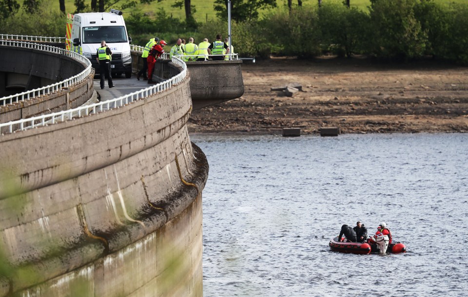 Police and emergency personnel searching a reservoir.