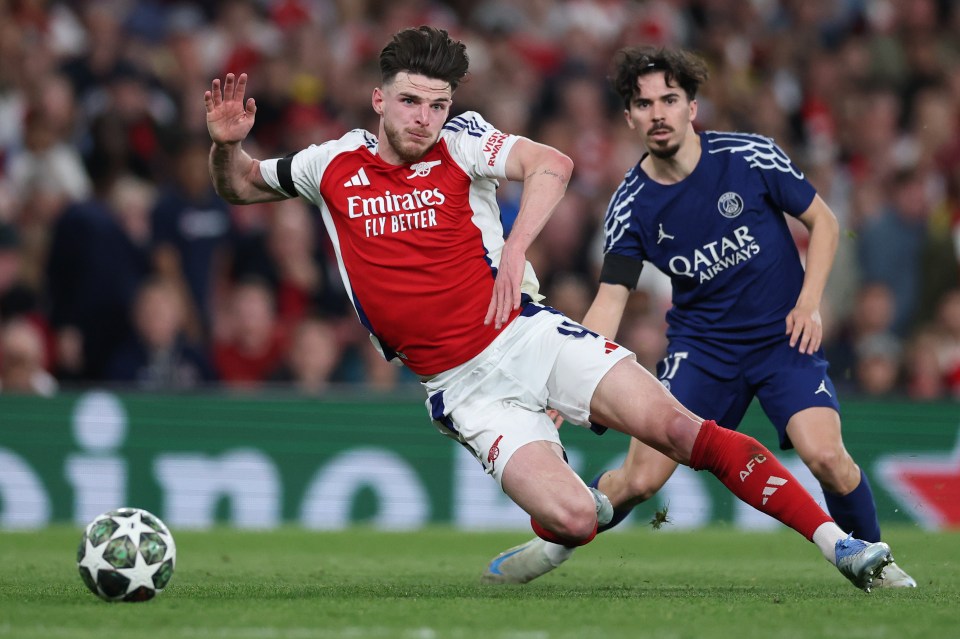 Declan Rice of Arsenal being fouled by Vitinha of Paris Saint-Germain during a soccer match.