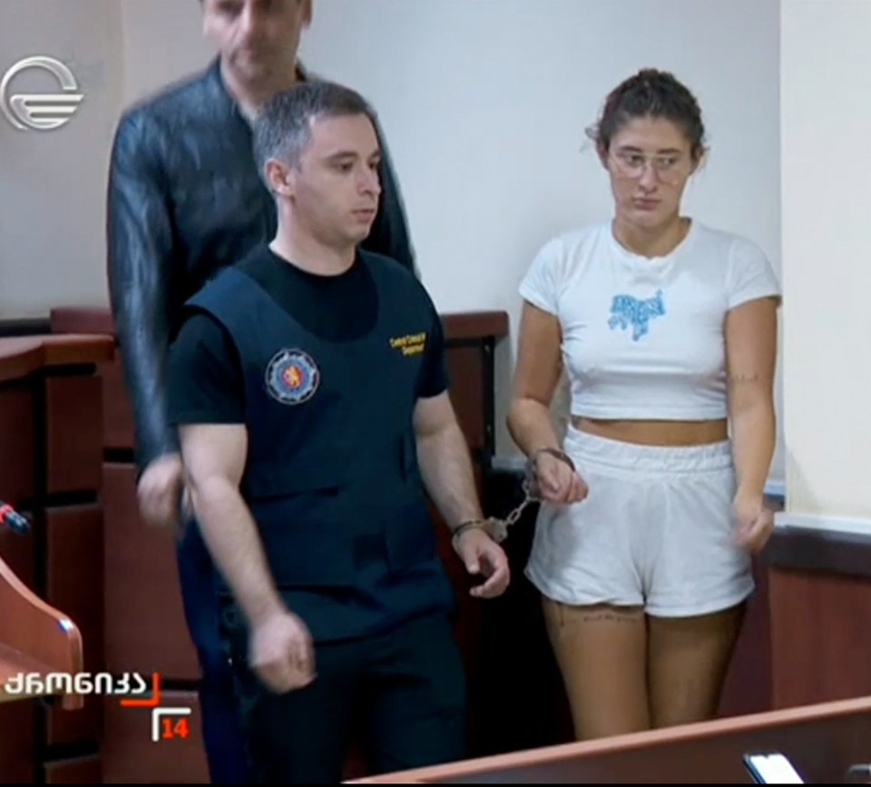 A handcuffed young woman in court.