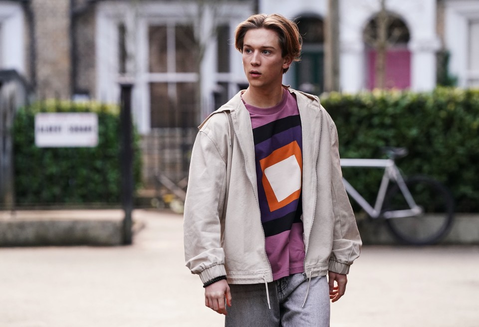 Joel from EastEnders walking down a street.