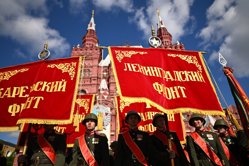 Russian servicemen carrying banners at a Victory Day military parade in Red Square, Moscow.