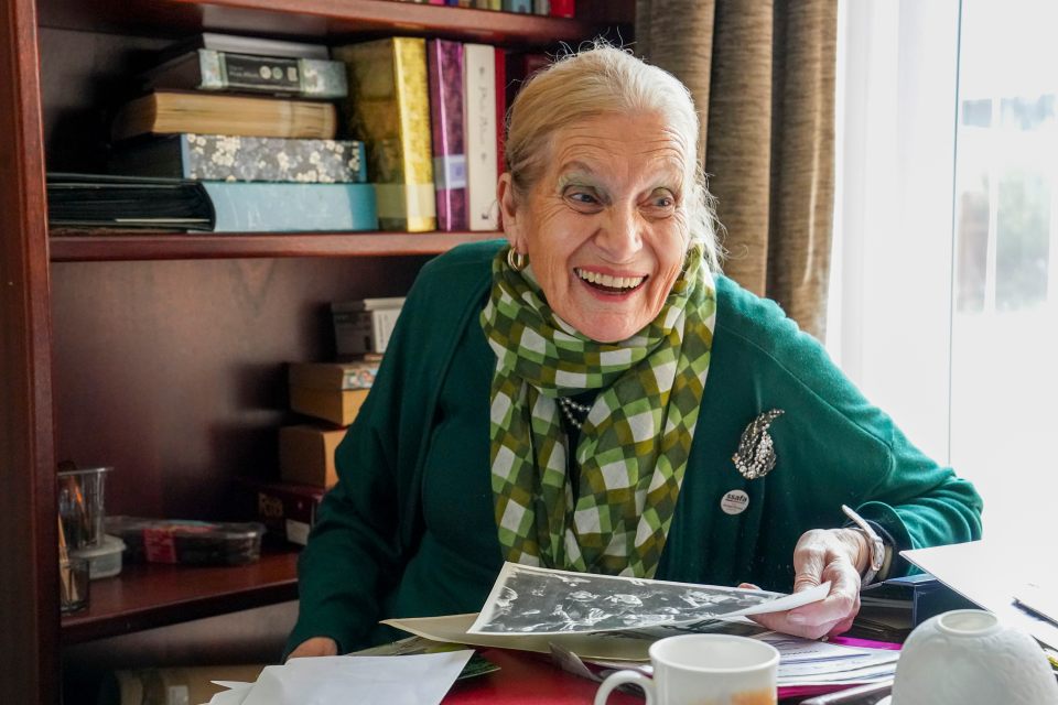 Smiling woman looking at photos, speaking at the Albert Hall on VE Day.