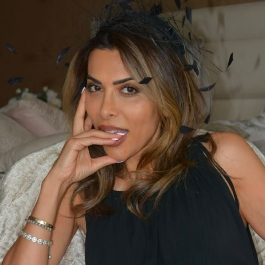 Portrait of a woman wearing a black headband and dress.