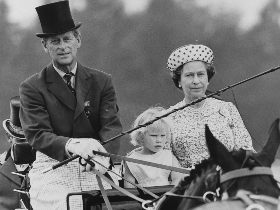 Prince Philip, Queen Elizabeth II, and Zara Phillips in a horse-drawn carriage.