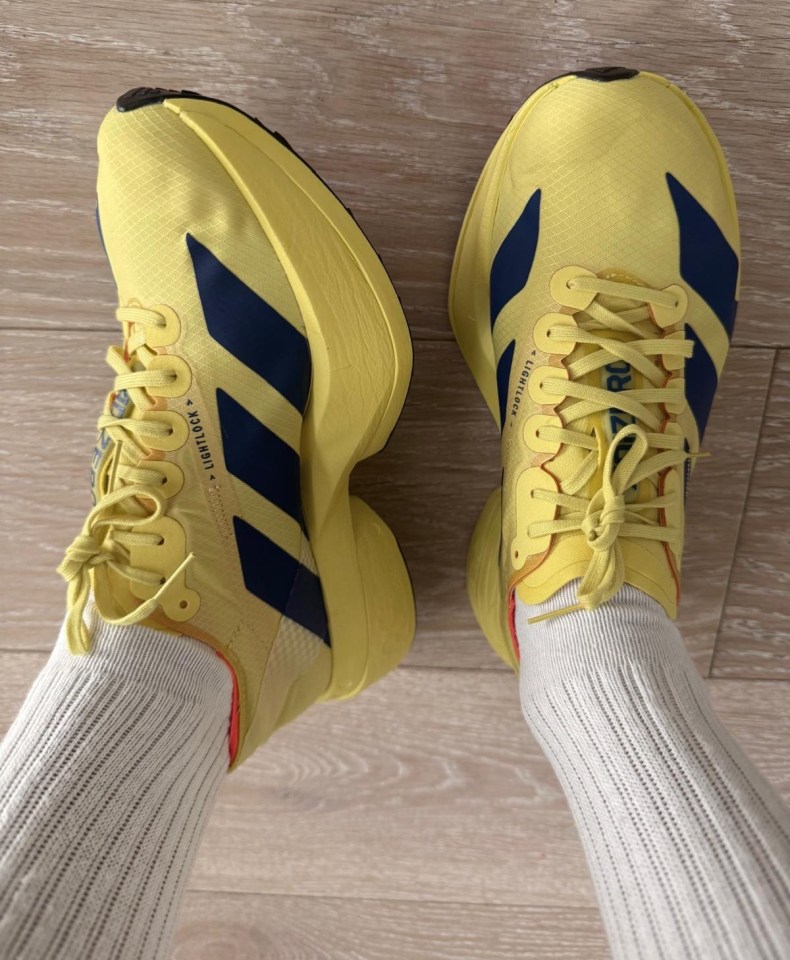 Yellow running shoes with navy blue accents.
