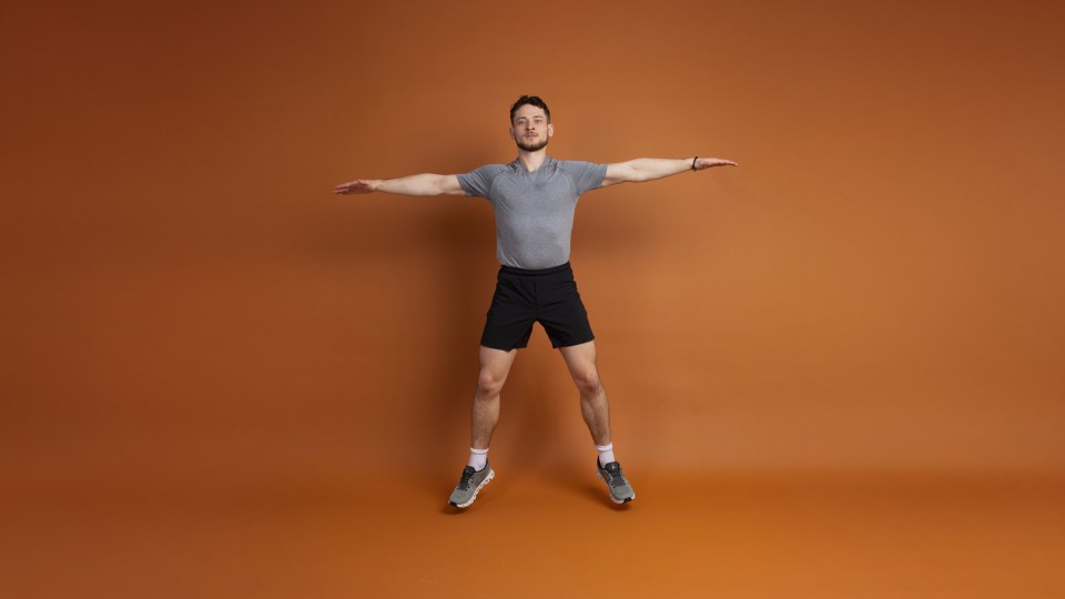 Man performing a jumping jack exercise.