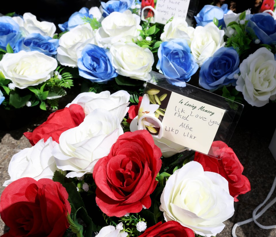 Floral tributes with a handwritten message.