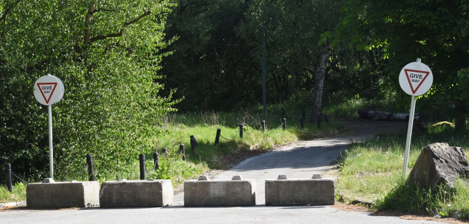 Give way signs and concrete barriers blocking a roadway.