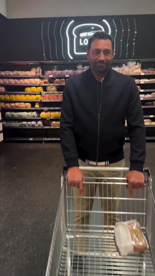 Man pushing shopping cart in grocery store.