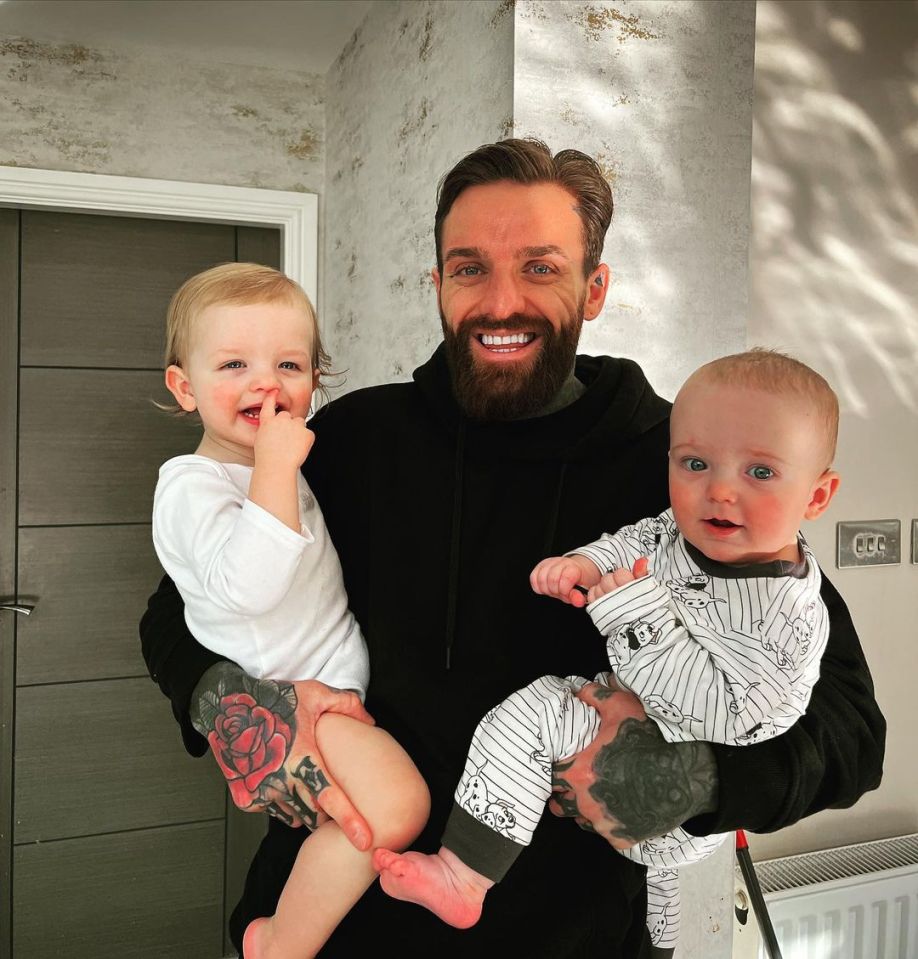Aaron Chalmers holding his two young children.