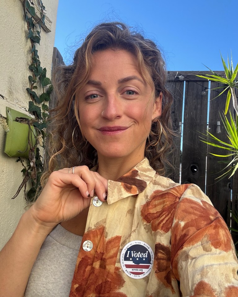 Woman showing off her "I Voted" sticker.