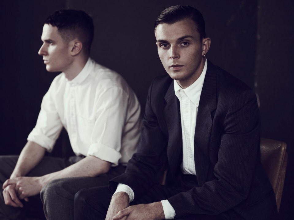 Portrait of two men, one in a suit and one in a shirt.