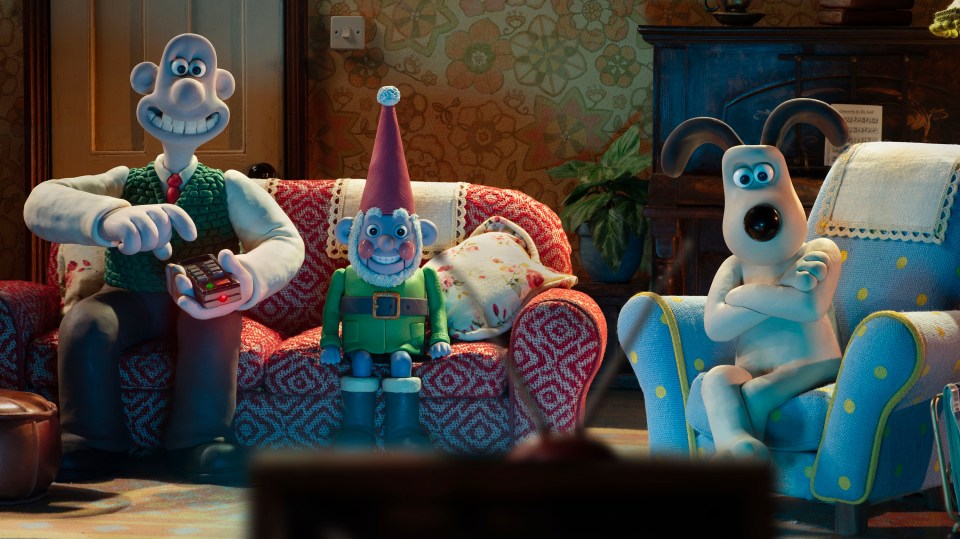 Wallace, Gromit, and a gnome watching TV.