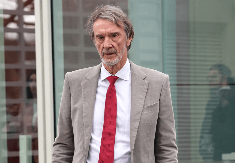 A man in a gray suit and red tie.