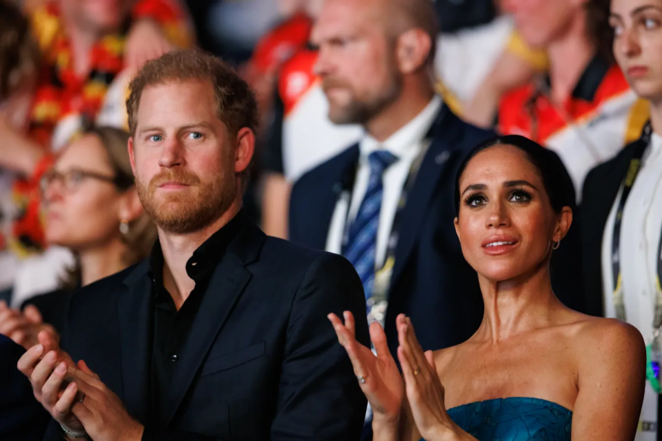 Prince Harry and Meghan Markle clapping.