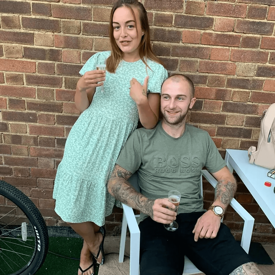 Couple holding drinks outside.