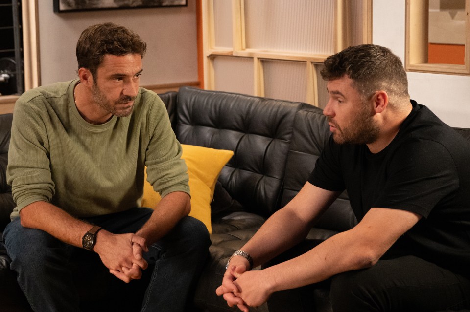 Two men sitting on a couch, talking.
