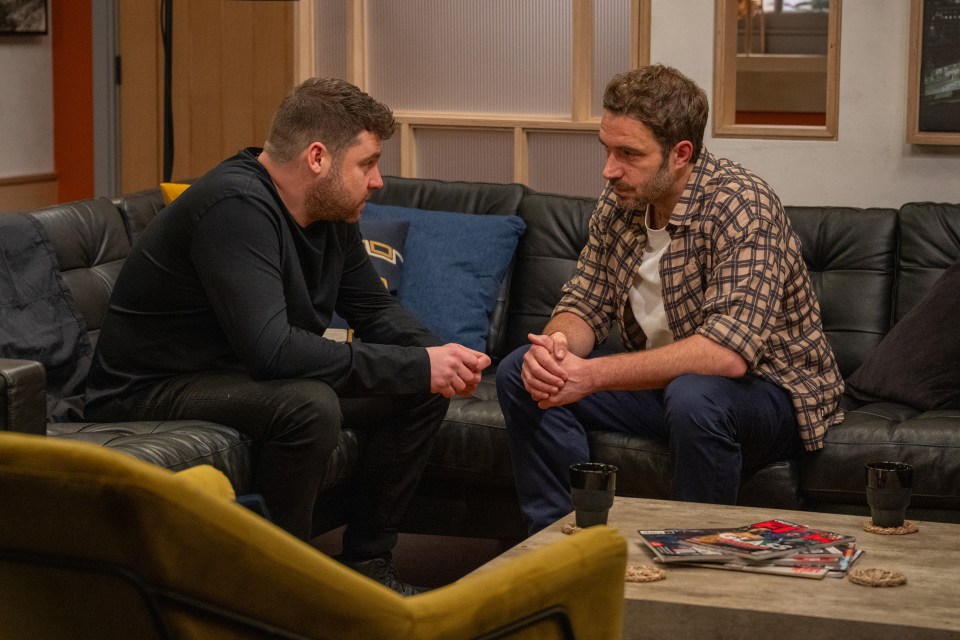 Two men sitting on a couch, talking.