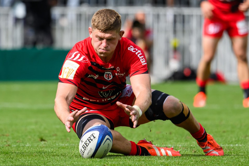 Rugby player diving for the ball.