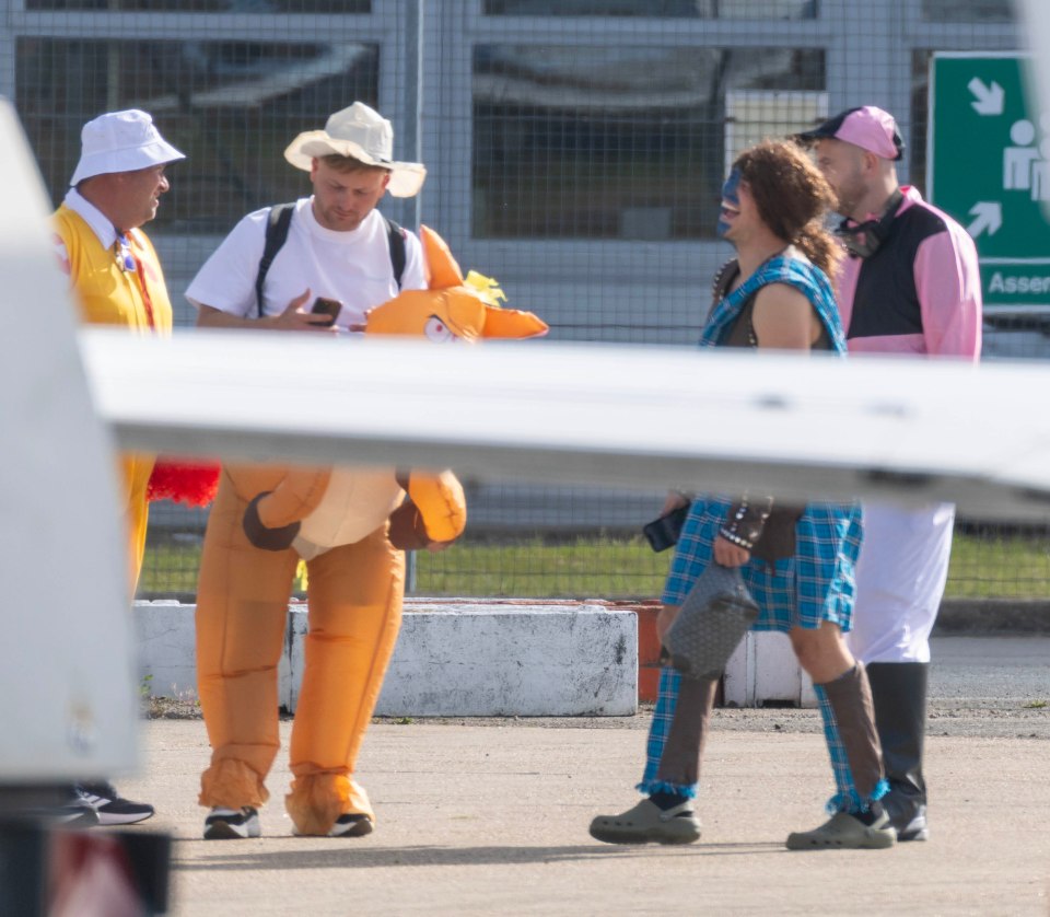 Men in various costumes boarding a private jet.