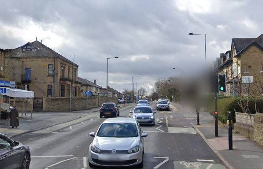 Street scene in Leeds with cars and buildings.