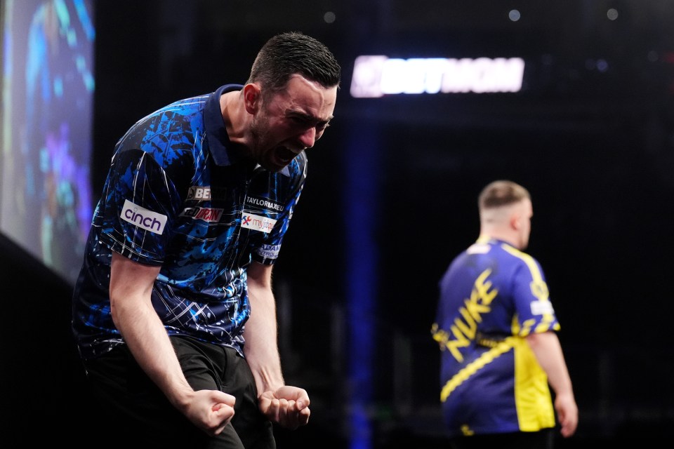 Luke Humphries celebrates a darts victory.