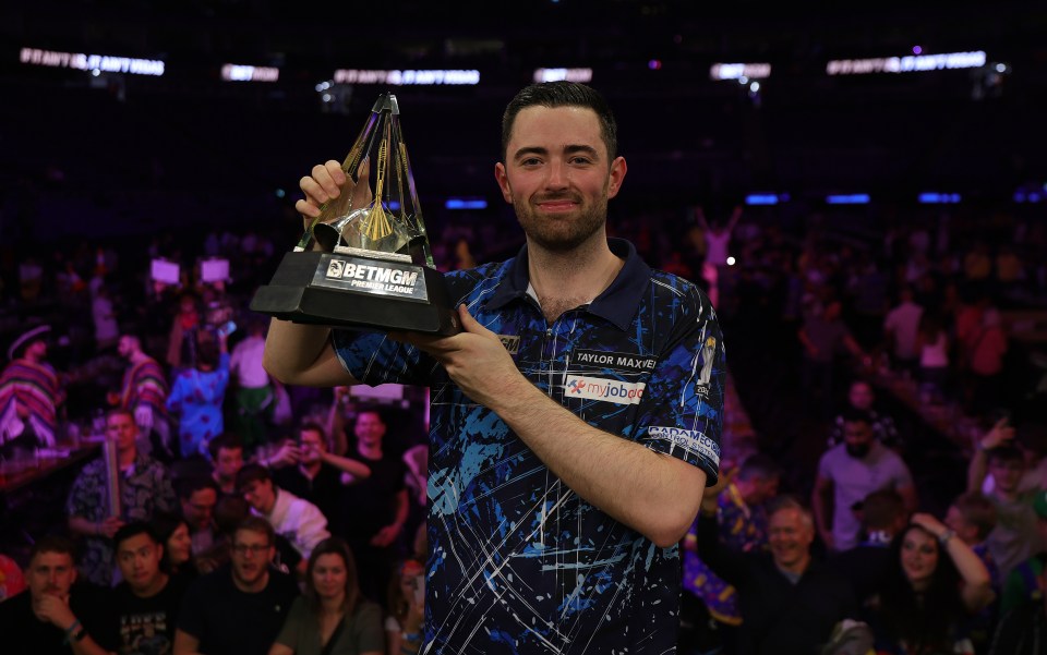 Luke Humphries of England holding the BetMGM Premier League trophy.