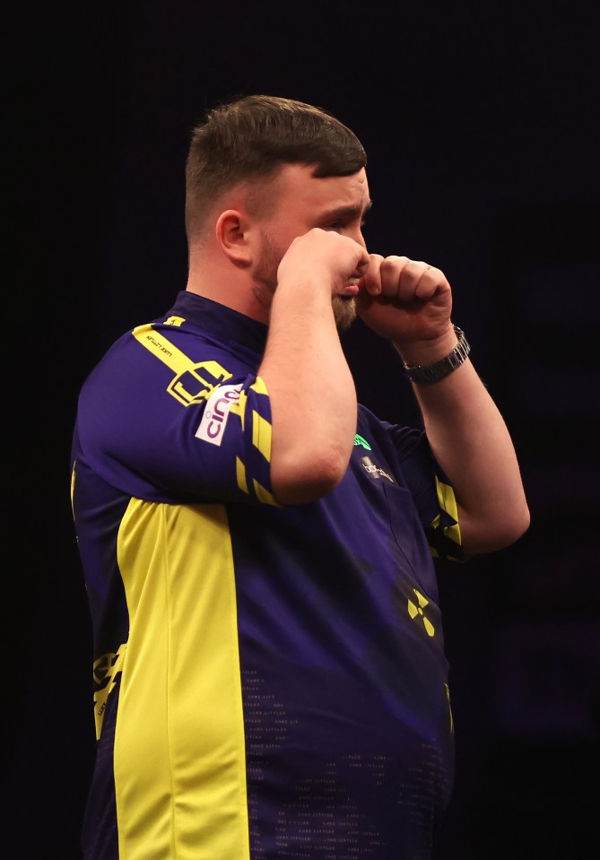 Luke Littler reacting during a darts match.