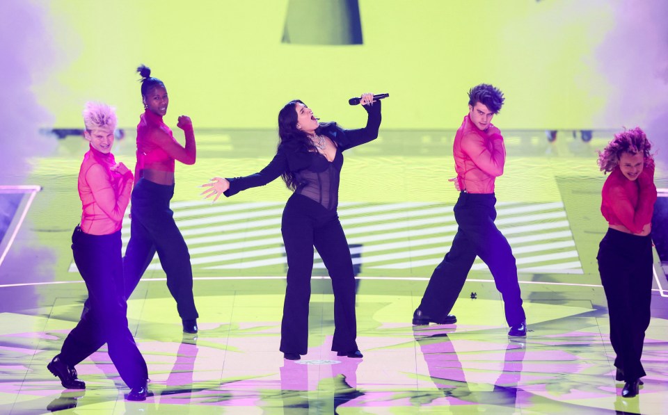 Mae Muller performing on stage with backup dancers at the Eurovision Song Contest.