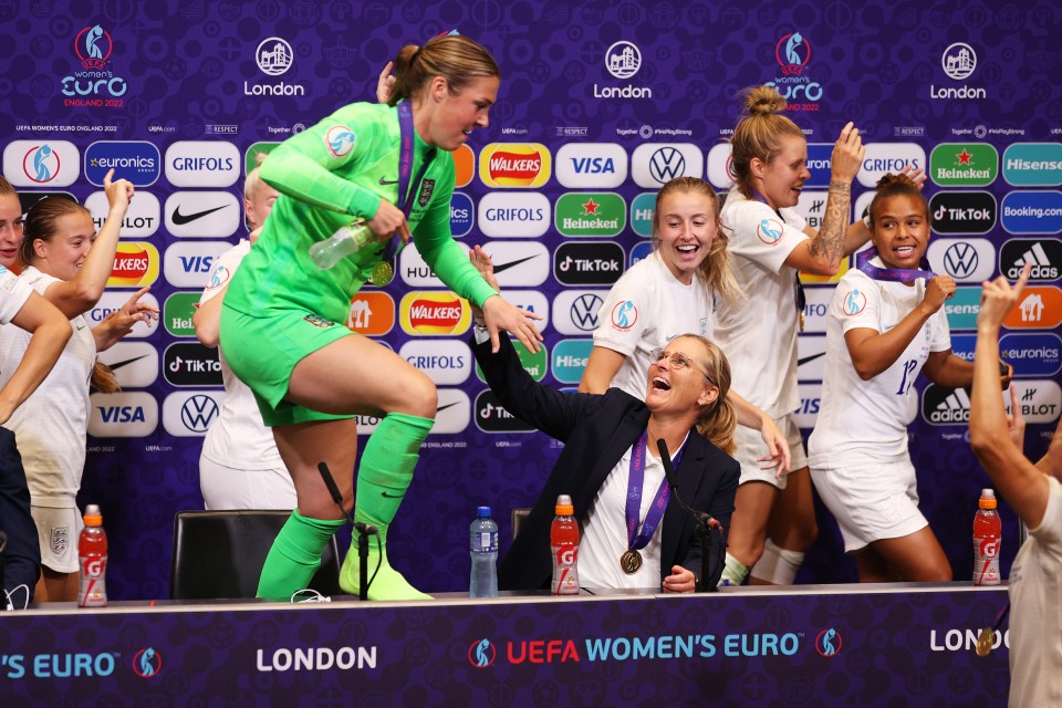 England's women's football team celebrating at a press conference.