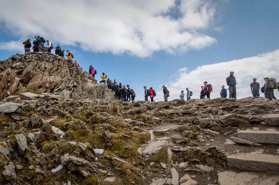 Hikers on the rocky summit of Mount Snowdon.