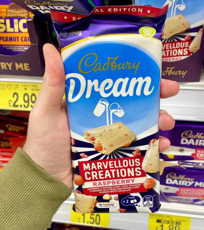 Hand holding a Cadbury Dream Marvellous Creations Raspberry chocolate bar.