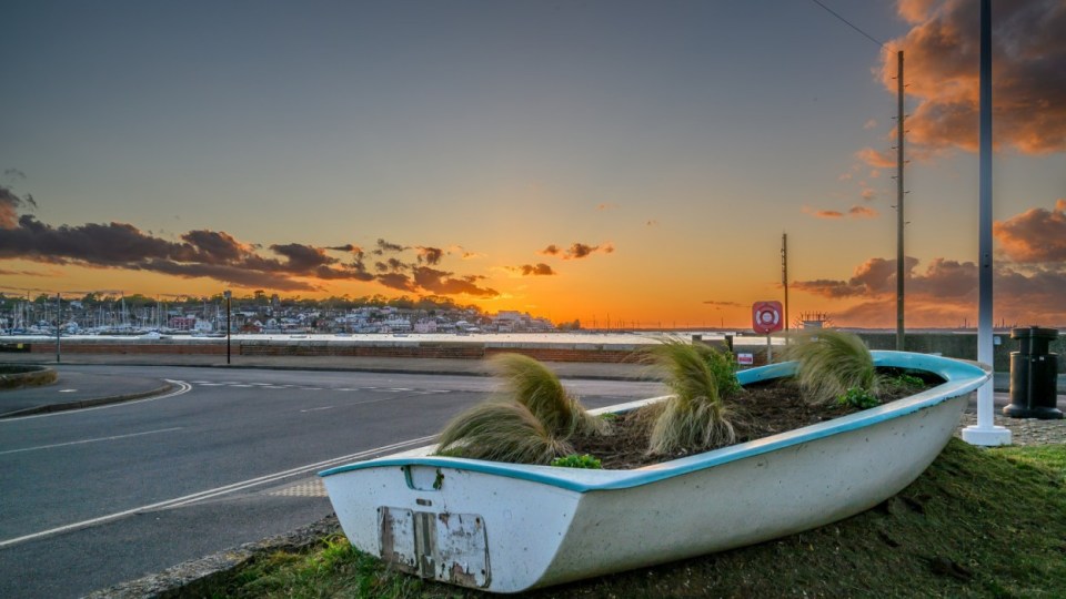 Sunset over East Cowes, with a boat planter in the foreground.