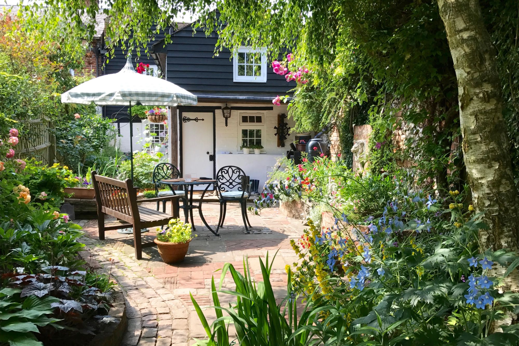 An image collage containing 1 images, Image 1 shows English cottage garden with patio furniture