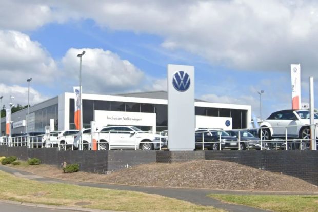 An image collage containing 1 images, Image 1 shows Photo of a large Volkswagen dealership with many cars on the lot
