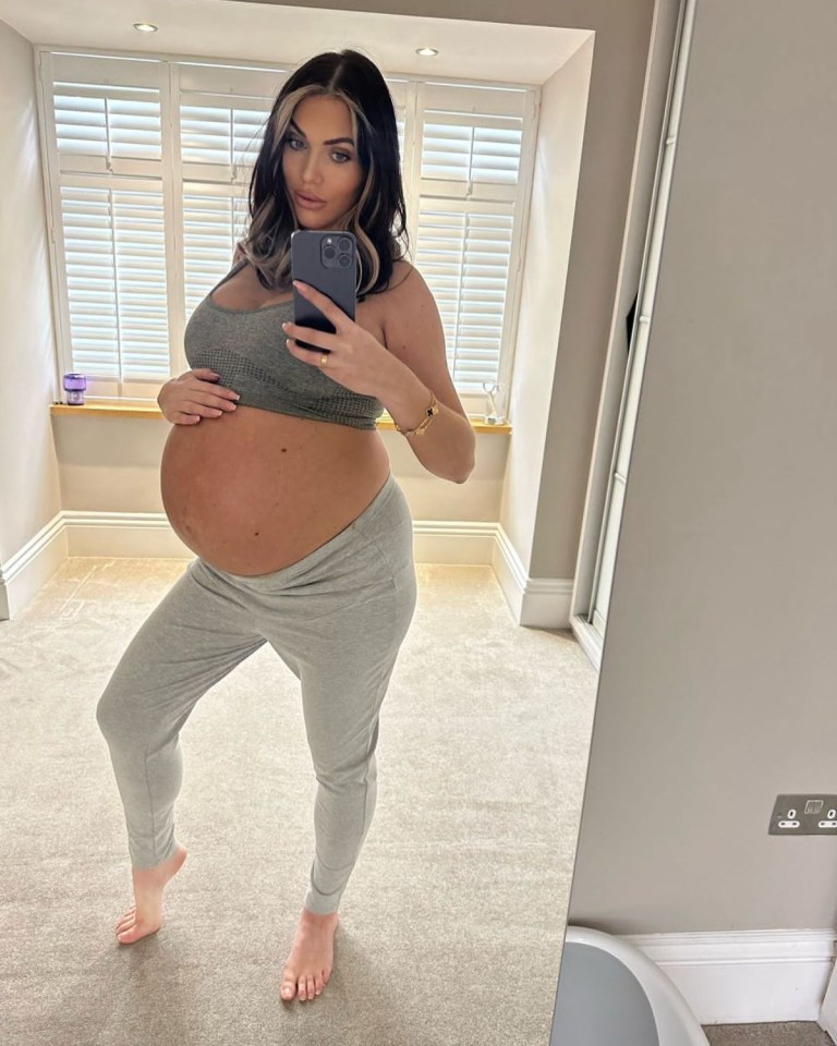 Pregnant woman taking a selfie showing her baby bump.