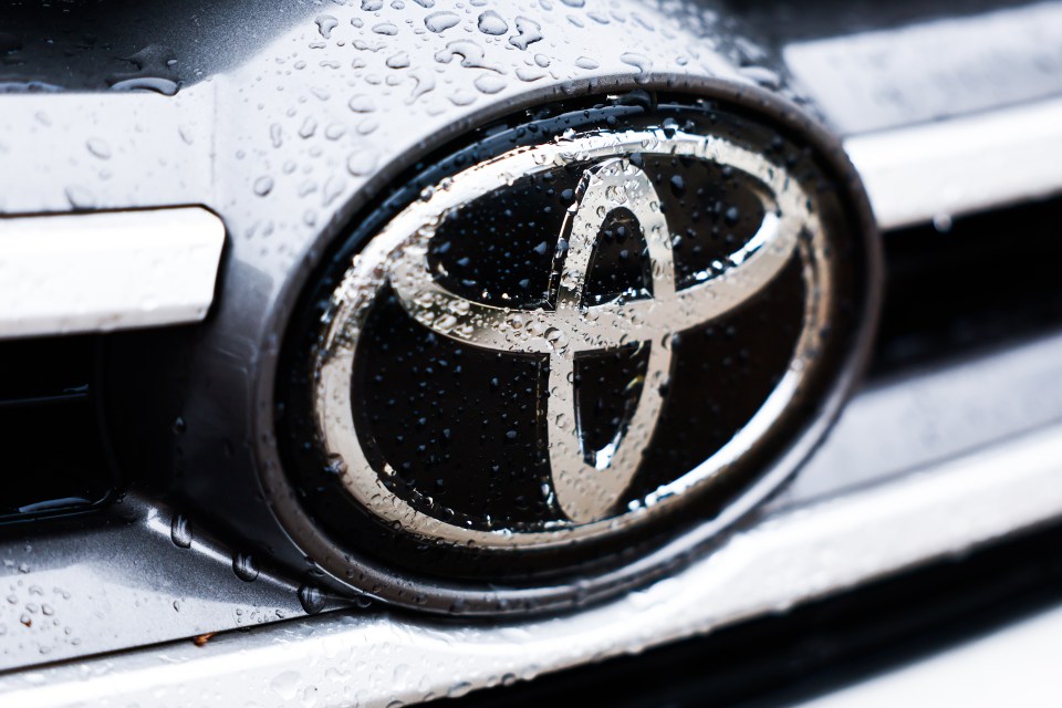 Close-up of rain drops on a Toyota logo.